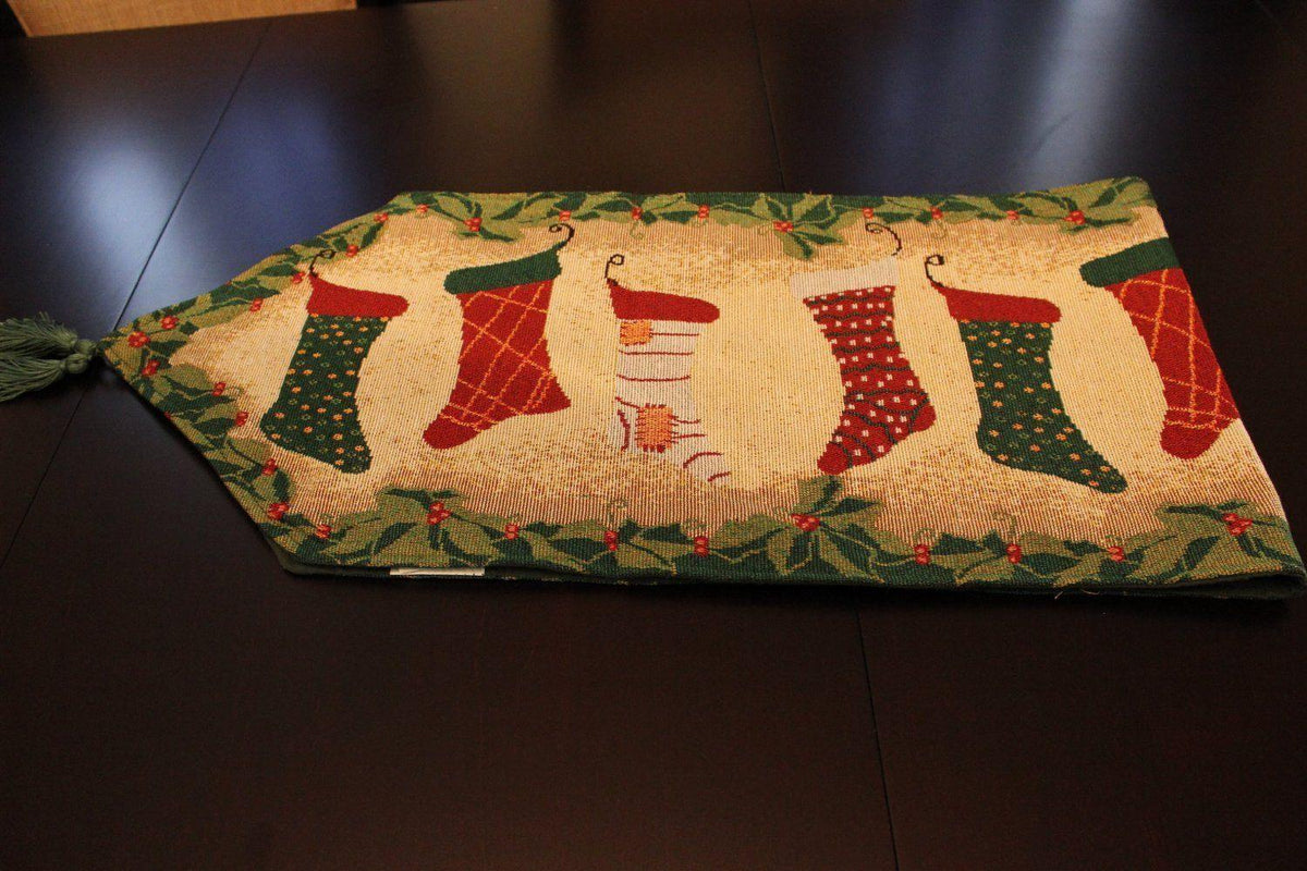Christmas table runner with stockings and fireplace decor wall hanging.