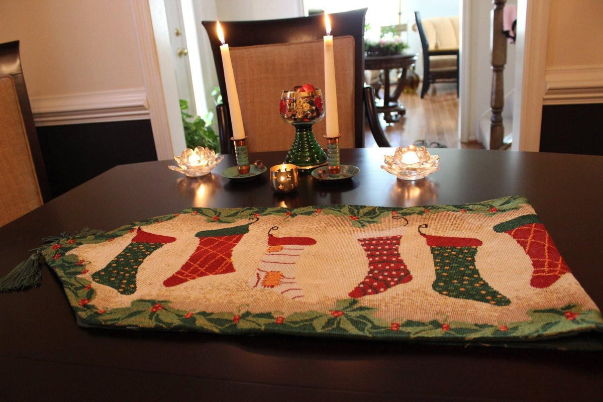 Christmas table runner with fireplace, stockings, and garland decor.