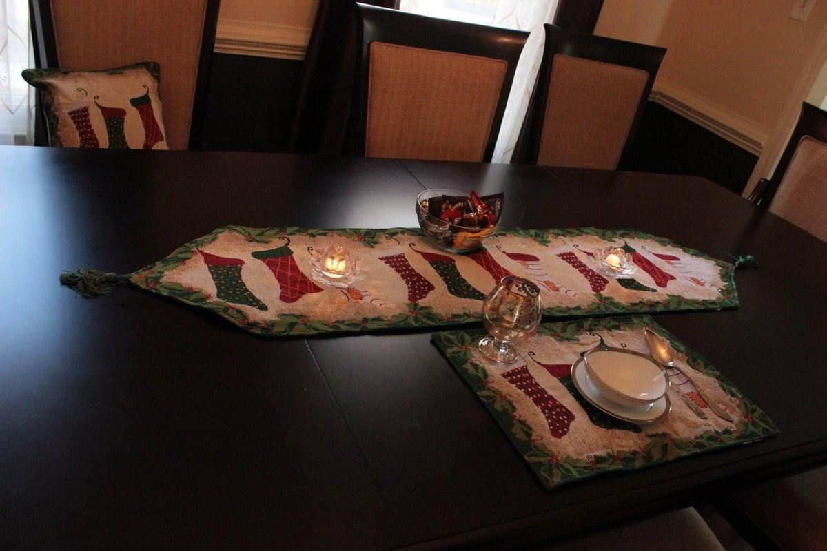 Christmas table runner with stockings and fireplace decor wall hanging.