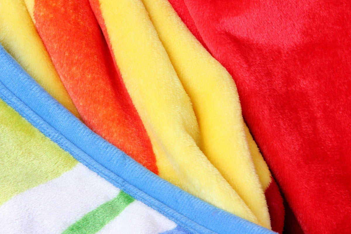 Luxurious reversible flannel fleece throw blanket with vibrant rainbow stripes.